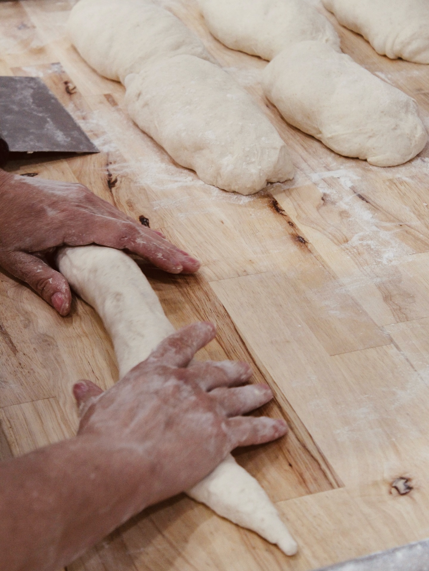 Hands shaping bread dough at Lady Baker