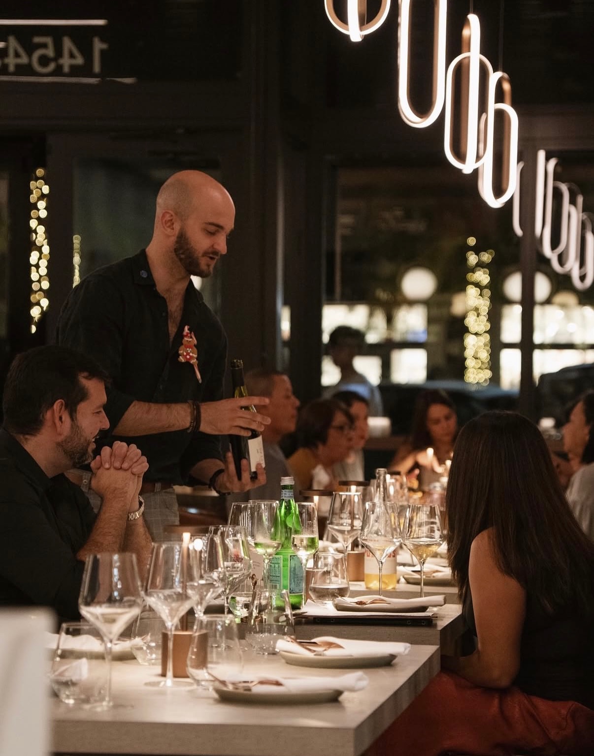 Wine being presented to guests at a shared table at LB Eatery & Wine